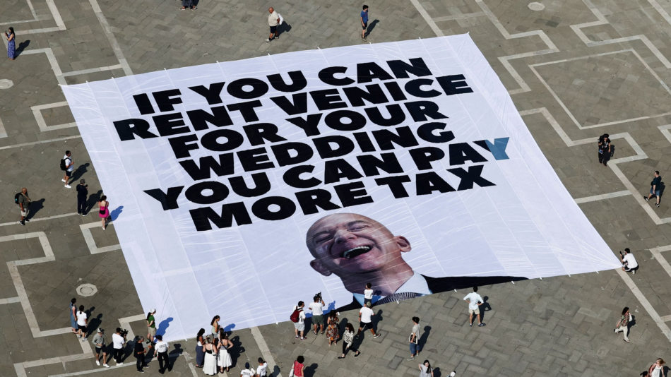 Enormous banner in a Venetian square protesting the Bezos wedding that bought out the city reading "If you can rent Venice for your wedding you can pay more tax"